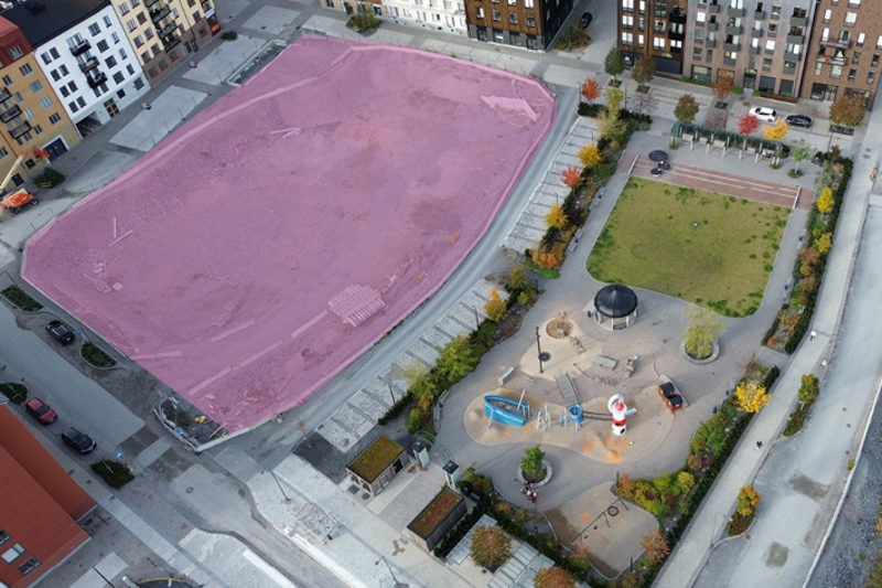 Flygfoto p&aring; stad och park med ett omr&aring;de markerat i rosa