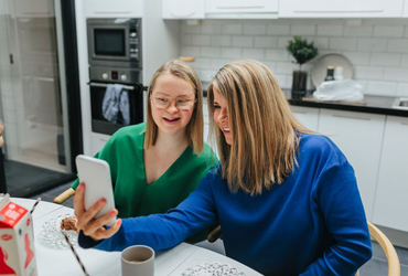 Tjejer tar  selfie vid matbord