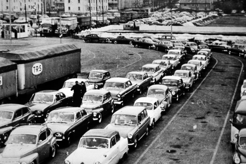 Svartvit historisk bild. Bilar i k&ouml; till f&auml;rjan p&aring; f&auml;rjel&auml;gret. Massor med bilar p&aring; rad i k&ouml;.