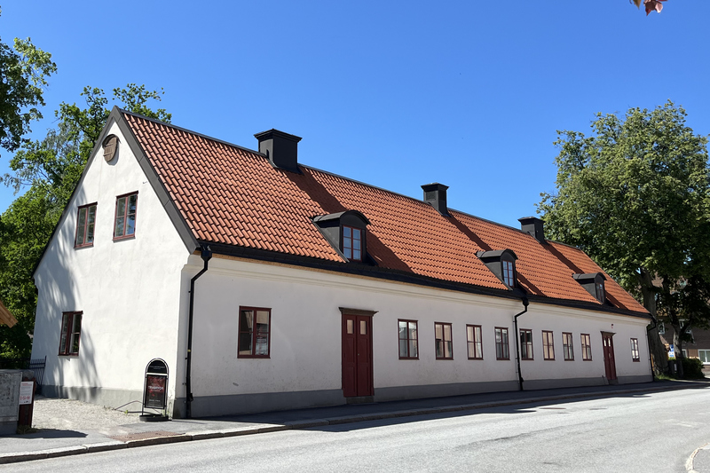 Roslagsmuseet &auml;r en vit avl&aring;ng byggnad med r&ouml;tt tegeltak