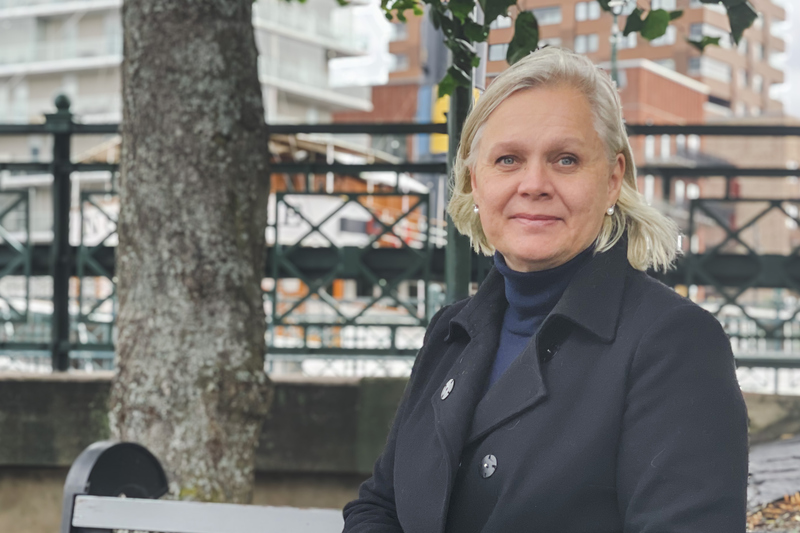 Stadsarkitekten i Norrtälje kommun, Charlotte Köhler, en vit kvinna med blont hår, svart kappa och blå polokrage.
