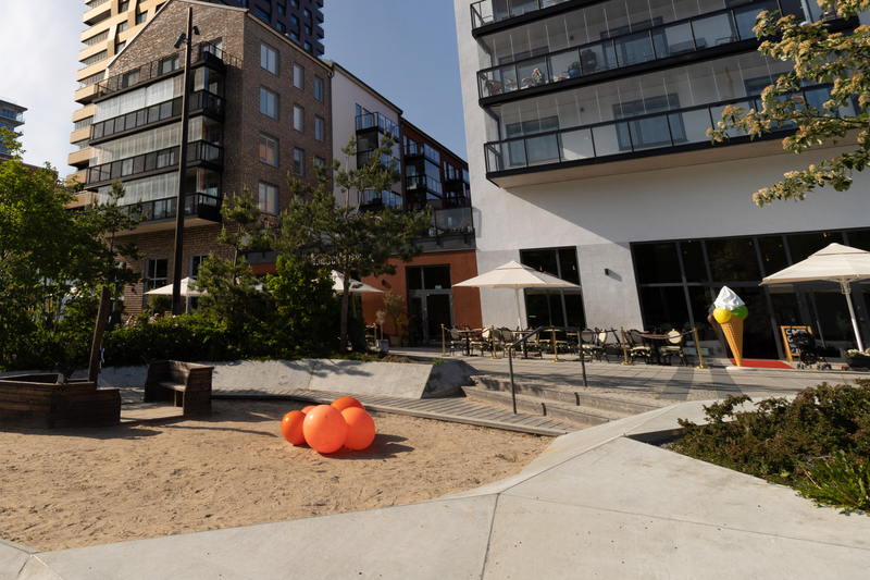 lekplats i förgrunden och uteservering i bakgrunden