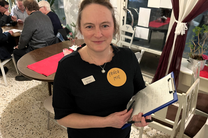 en kvinna st&aring;r med ett anteckningsblock