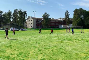 stor grönyta där det spelas fotboll