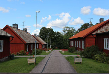 Små röda hus på rad mittemot varann med en rak väg emellan