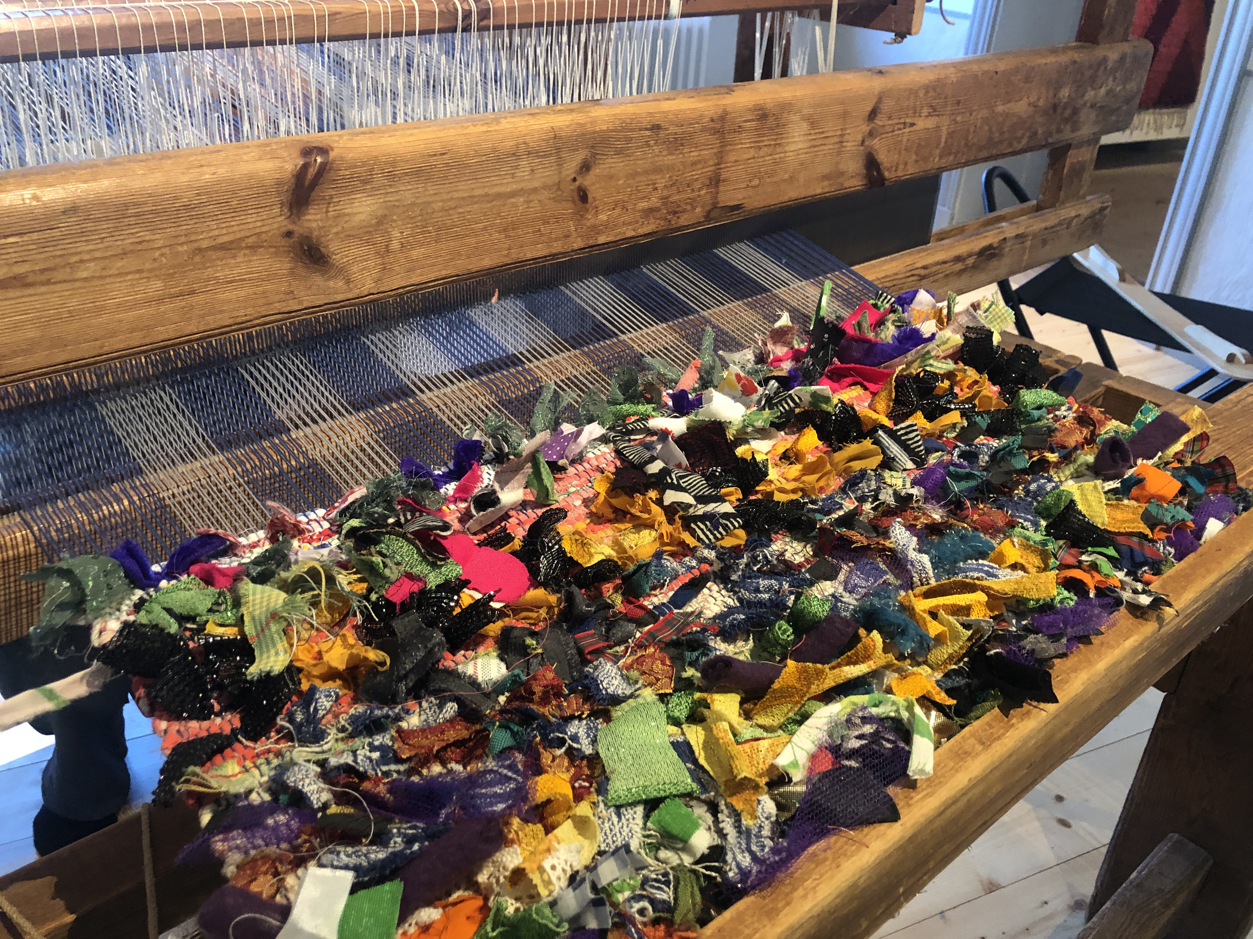 En vävstol med färgglada trasor i. 