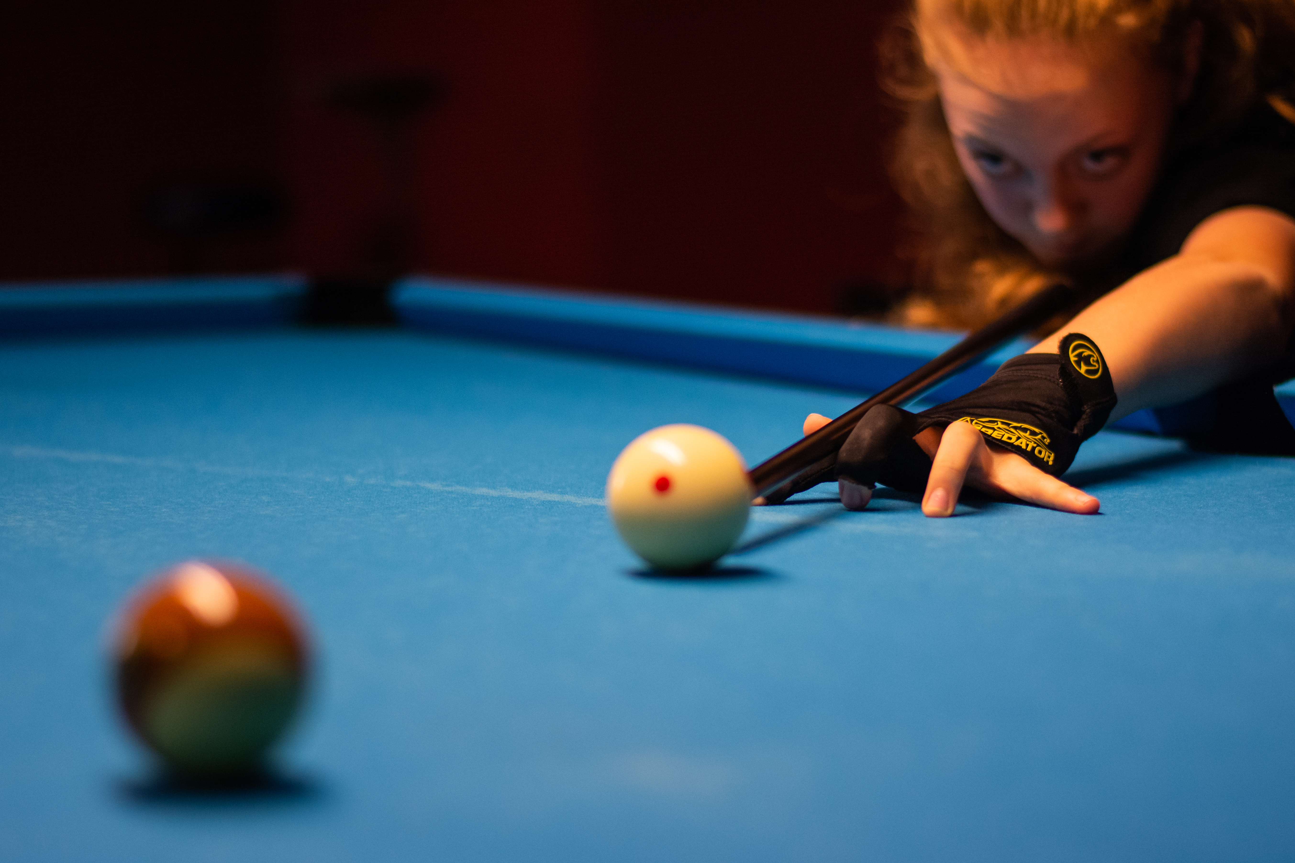 Ung tjej spelar biljard.