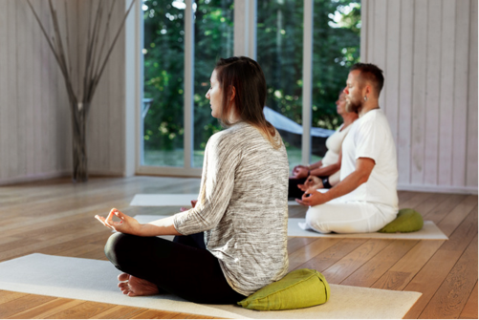 Två personer som sitter i lätt meditationsställning.