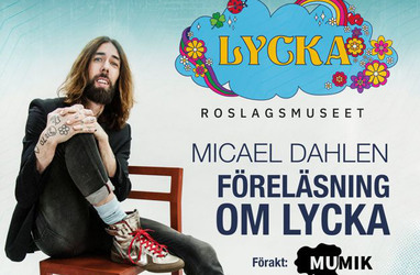 Micael Dahlen sitter på en stol med ena benet uppdraget i händerna