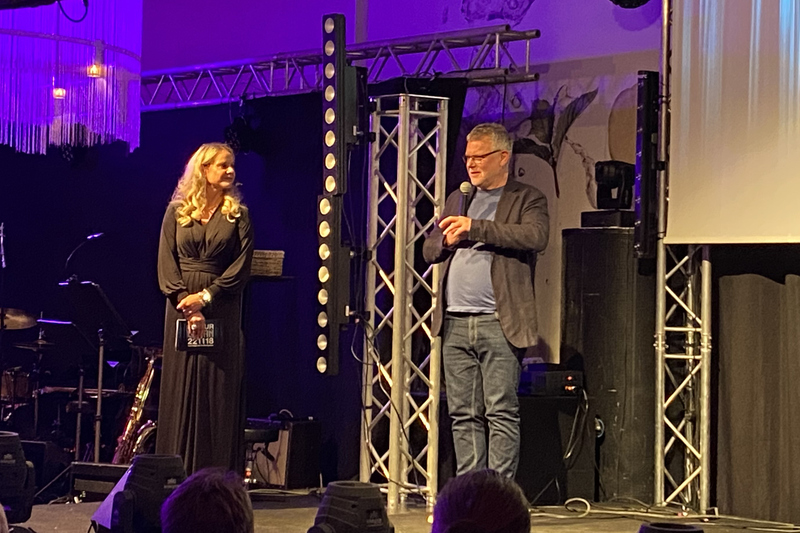 Författaren Arne Dahl står på scenen. Arne Dahl är klädd i jeans och svart kavaj.