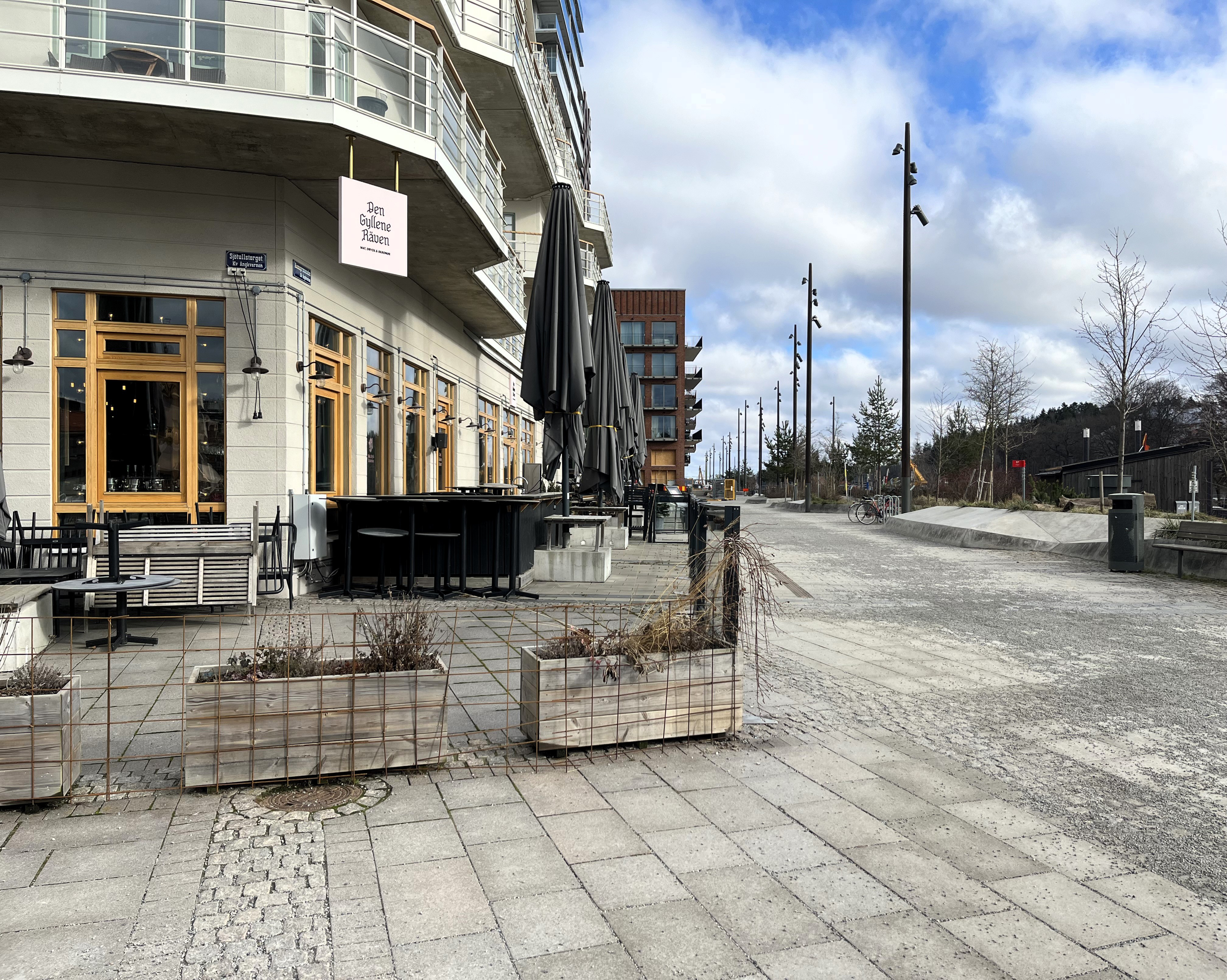 Gata, uteservering och hus med restaurang i bottenv&aring;ning