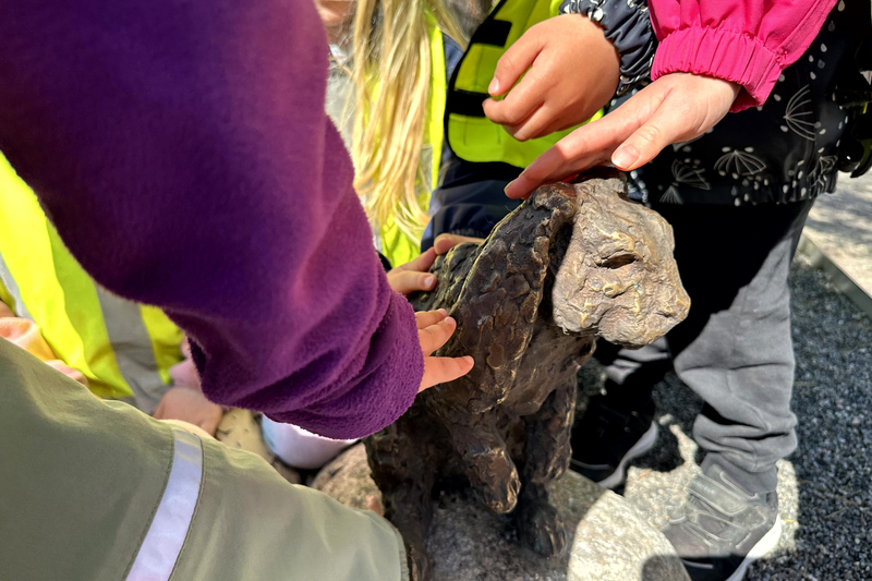 Barnh&auml;nder som klappar en bronskanin