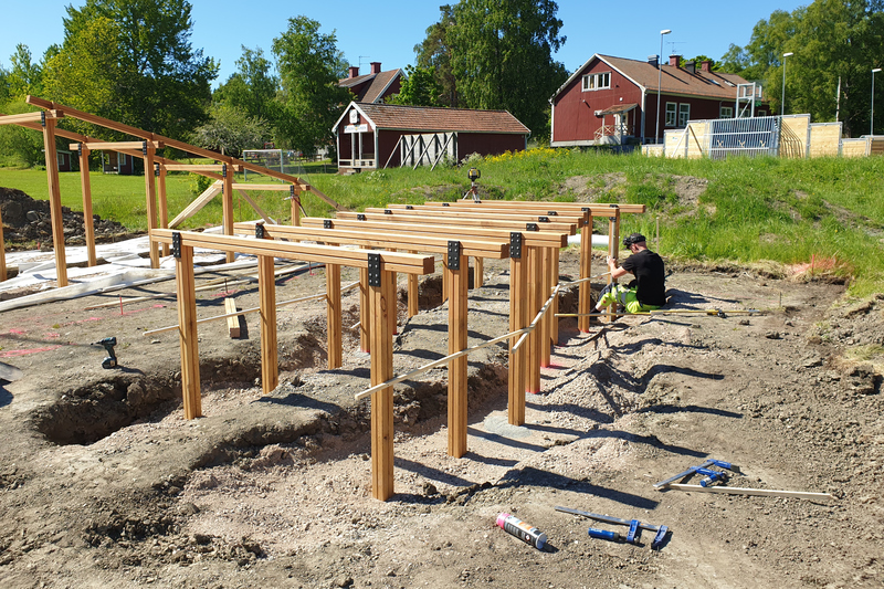 person i varsel bygger en tr&auml;ram till en lekplats.
