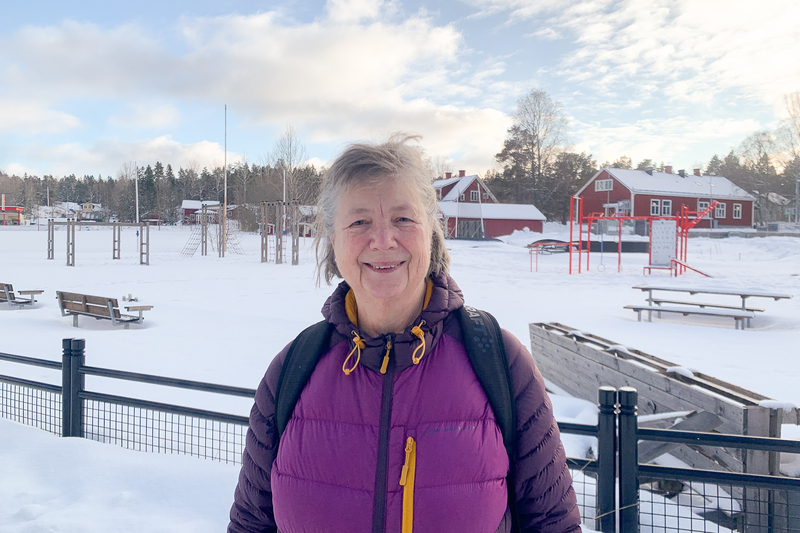 Person i sn&ouml;landskap framf&ouml;r lekplats.