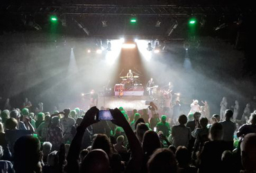 Musiker på scen och  fullsatta publikplatser