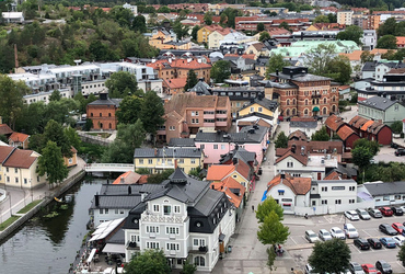 vy över stadskärna med hus, gator, bilar och människor