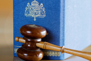 Bild på rättegångsklubba med lagbok i bakgrunden.