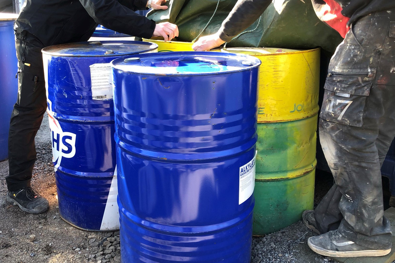 Flera personer vis metalltunnor