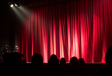 Bild av en scen med en röd ridå och en spotlight